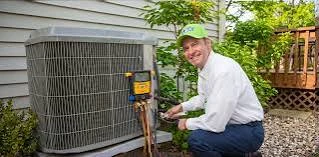 Technician checking an outdoor condenser beside a home